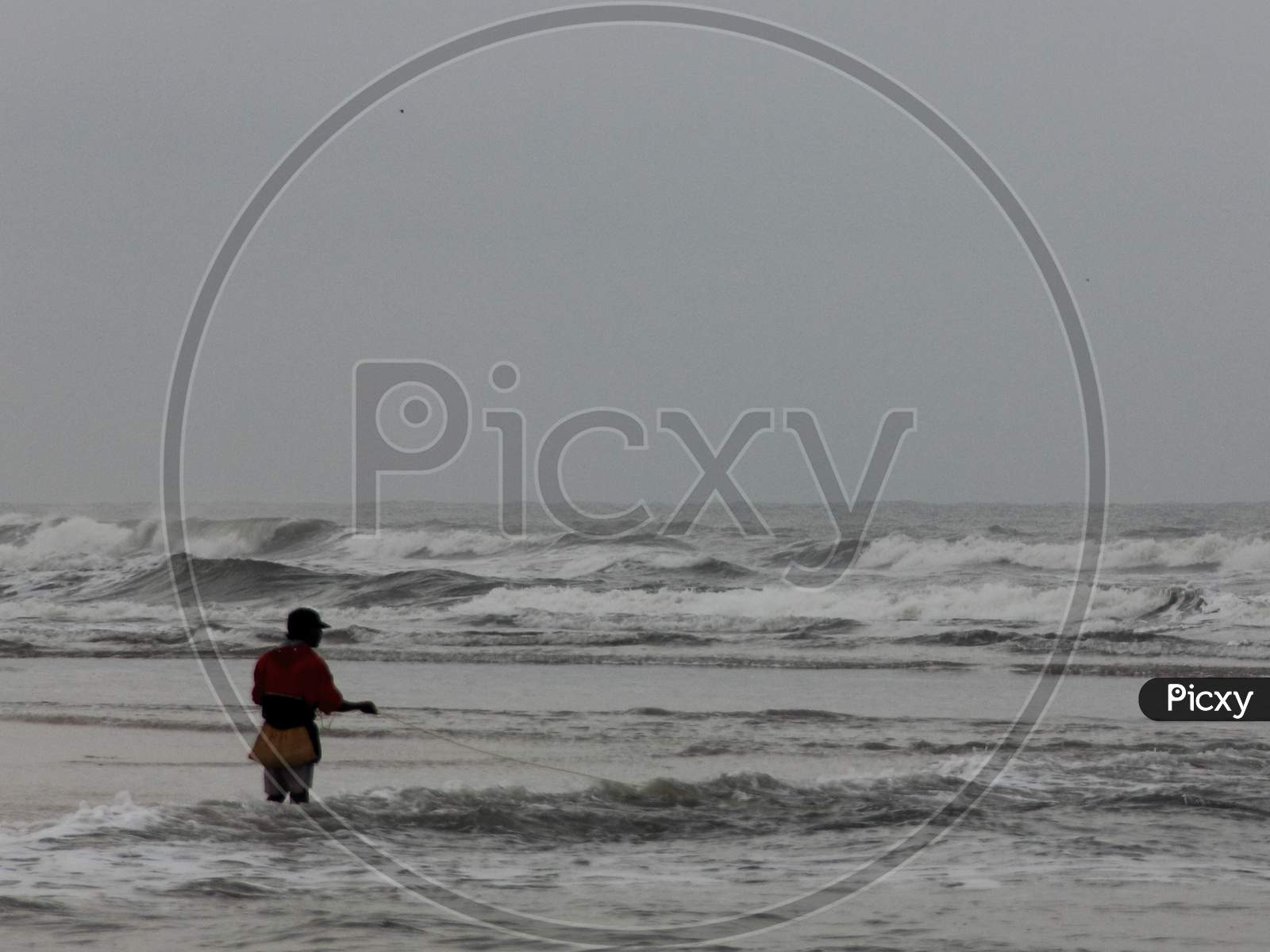 Fisherman on Baga Beach, fishin in sea, North Goa, India