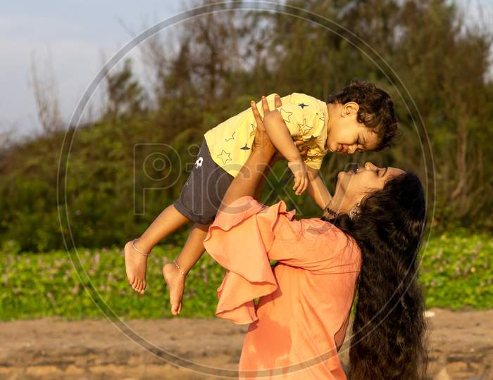 An Indian Mother And Child Happily Swing Around In An Open And Pure Environment