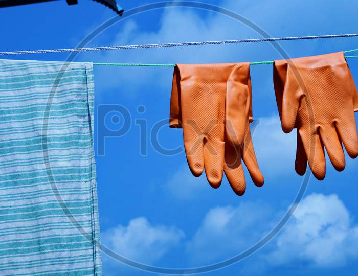 After wash use red gloves, hanging gloves with blue sky for protecting by corona virus