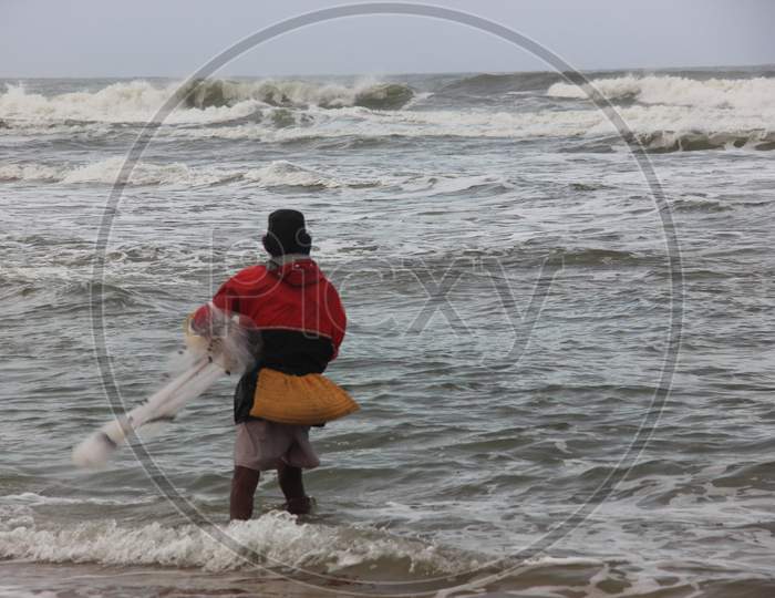 Fisherman on Baga Beach, fishin in sea, North Goa, India
