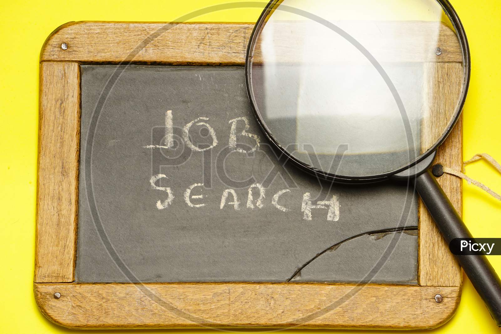 Top View Of Blackboard With Job Search Message With A Magnifying Glass Next To It. Flat Lay