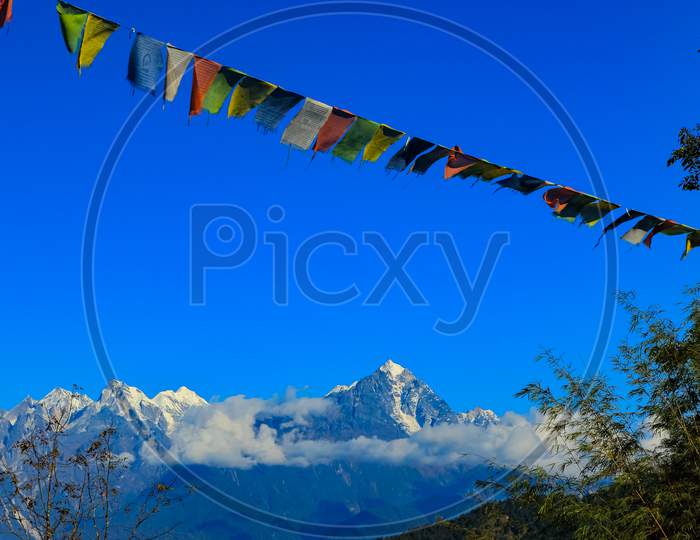 Colorful Tibetan prayer flag with snow clad mountains in the background