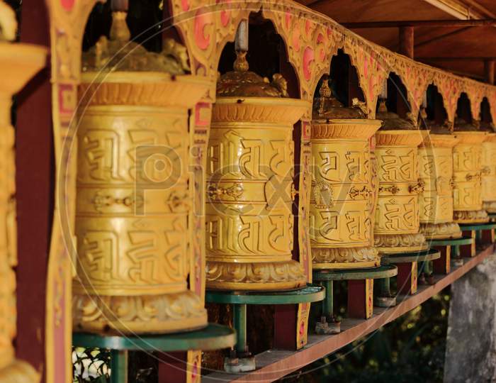 Buddhist prayer wheels in a row in a Tibetan monastery in Sikkim India