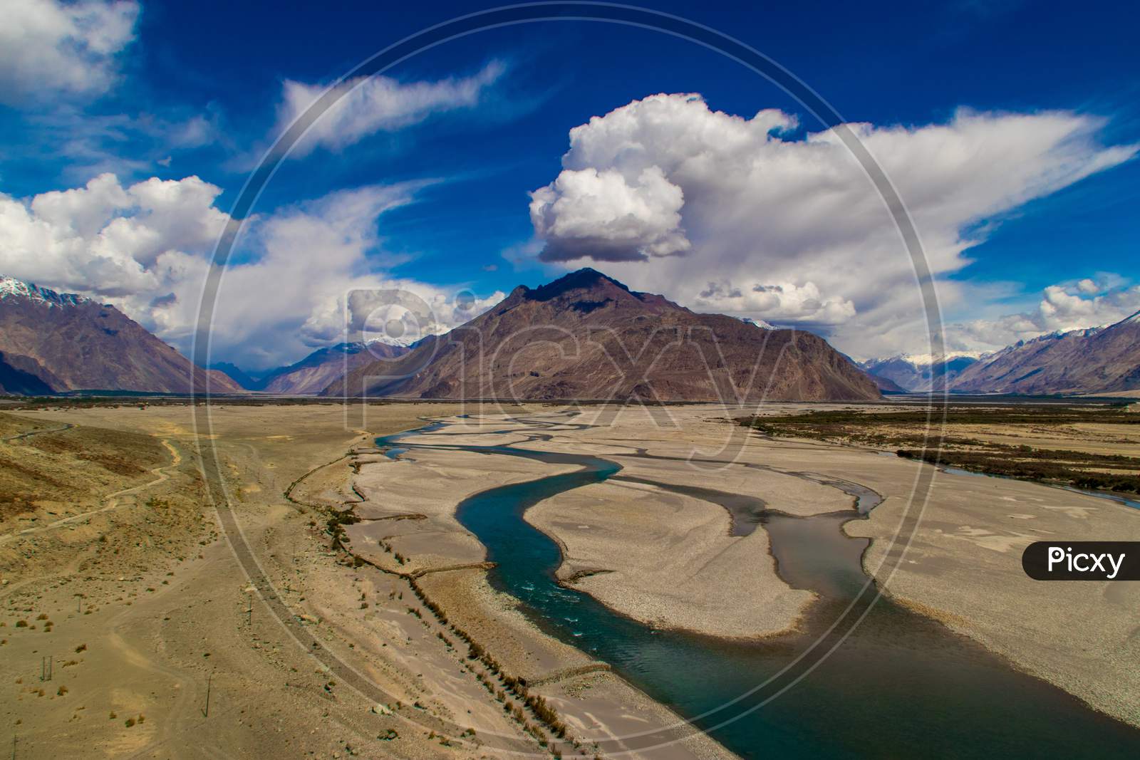River bed with mountains and clouds in frame