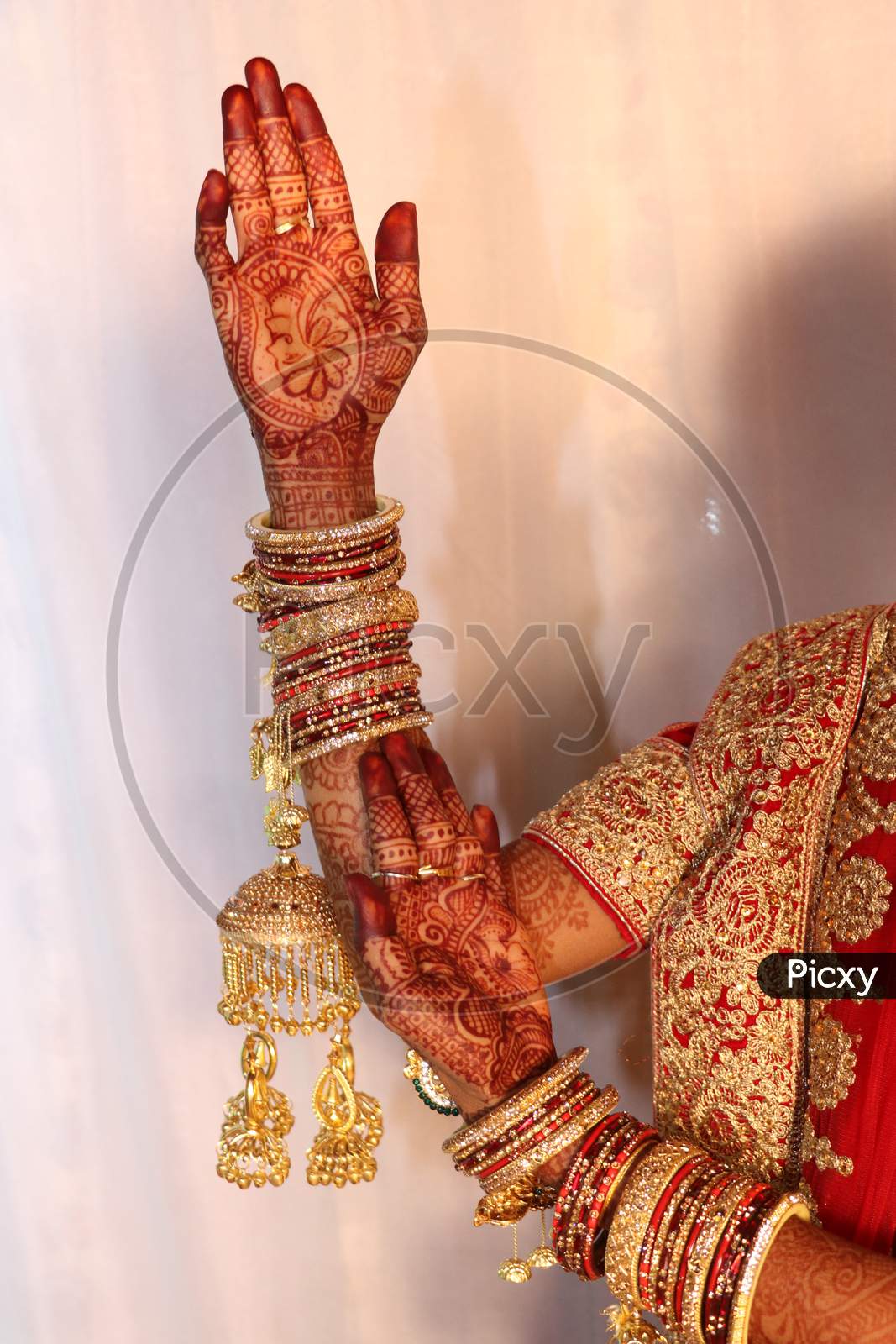 Beautiful Indian bride hand with mehandi design and jewelry .