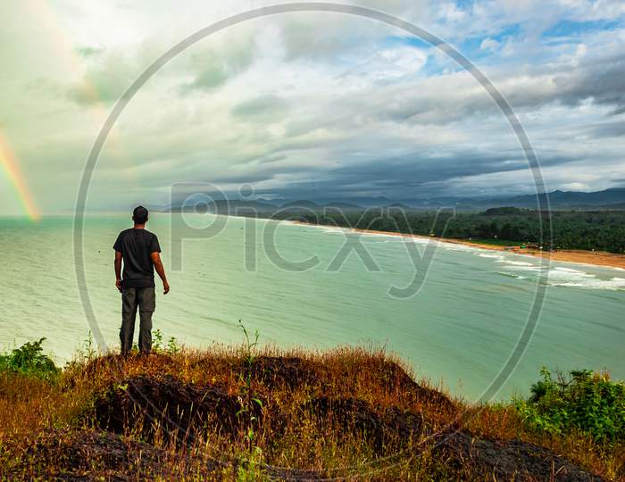 Man At Hilltop Enjoying Amazing Landscape Of Sea Shore