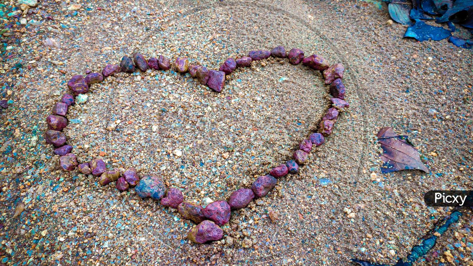 Heart made of Red rock in sand