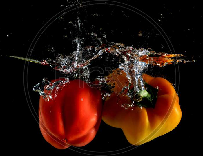 Red and Yellow Capsicum and Water Splash