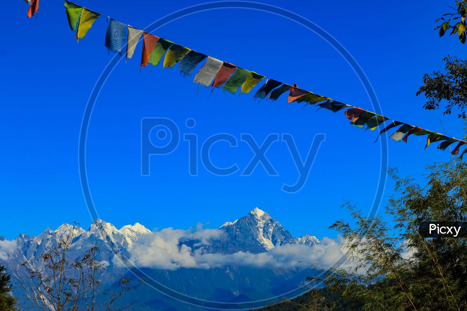 Colorful Tibetan prayer flag with snow clad mountains in the background