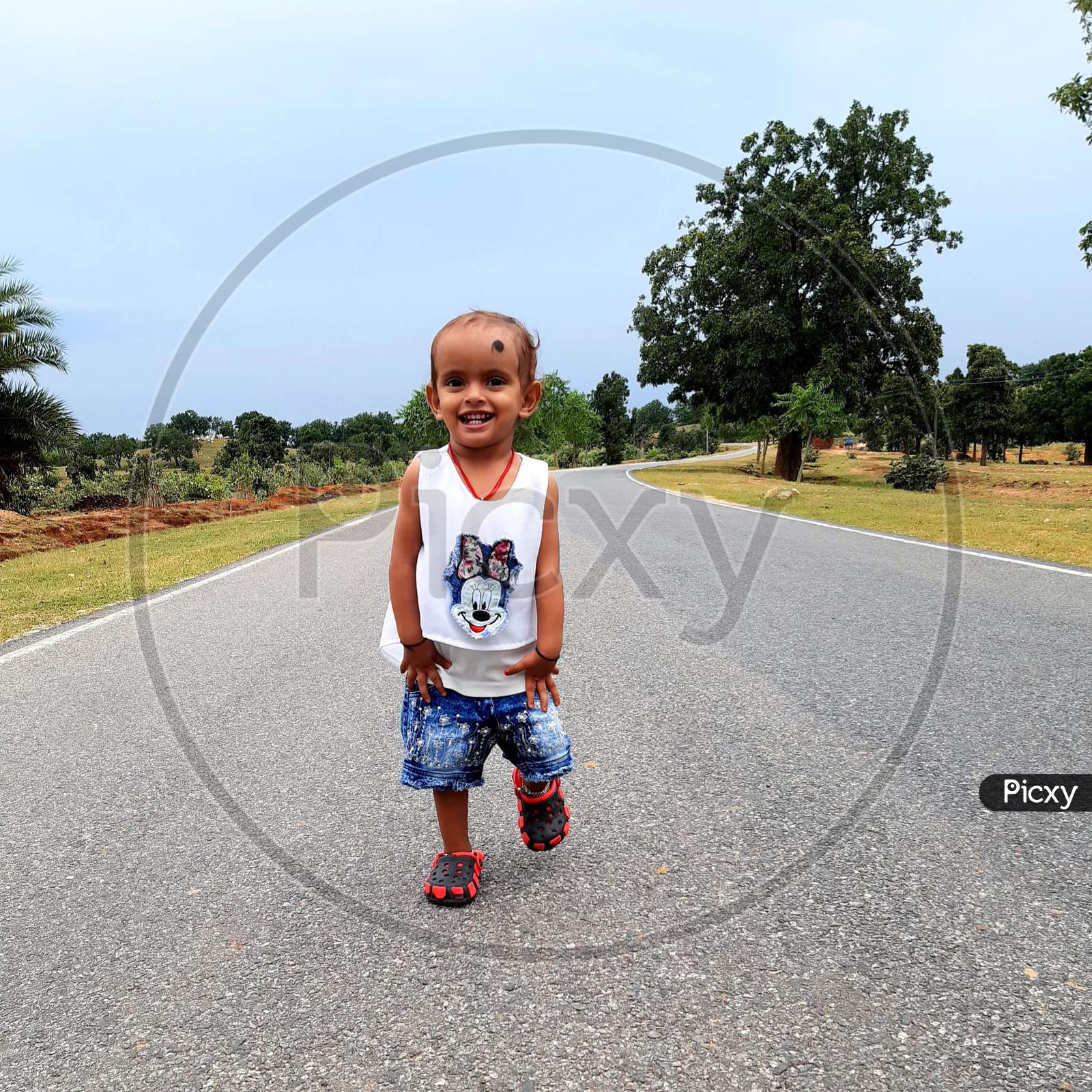 A cute baby girl walking in the Road