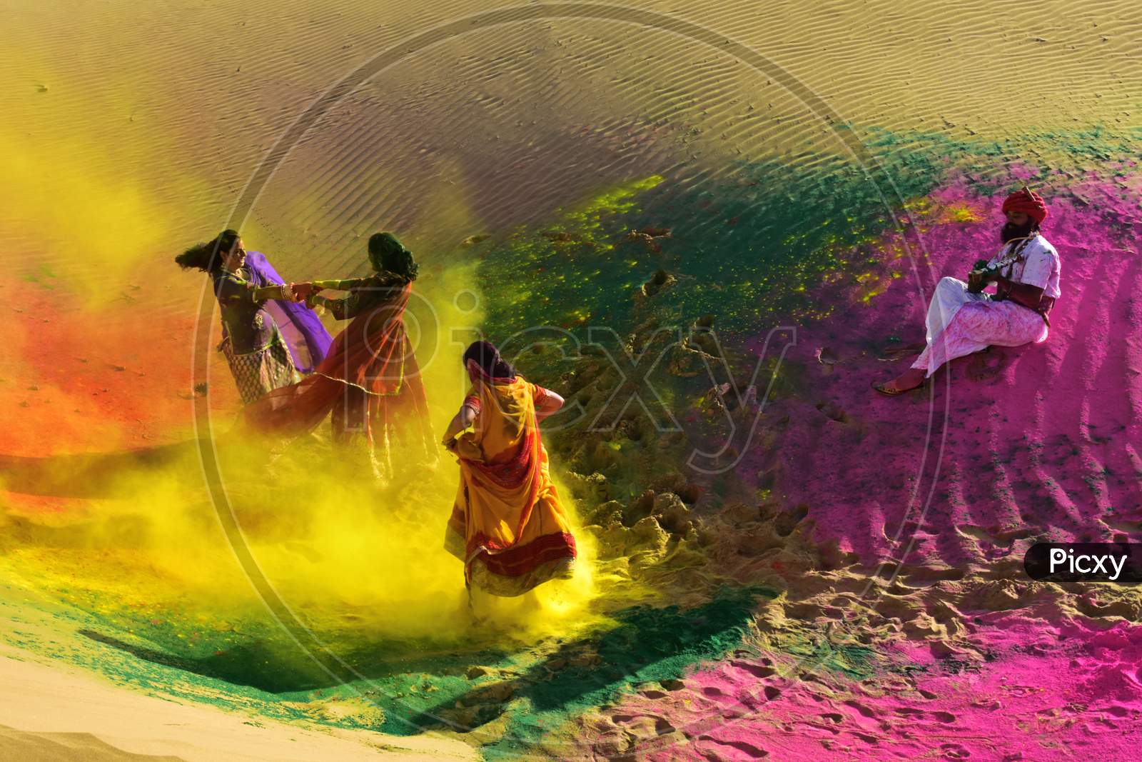 Three girls are enjoying Holi with various colours and a man playing a musical instrument