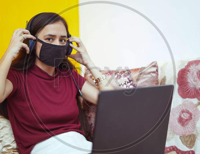 Close Up Of A Young Indian Girl Working On Her Laptop Wearing Headphones, Work From Home Concept.