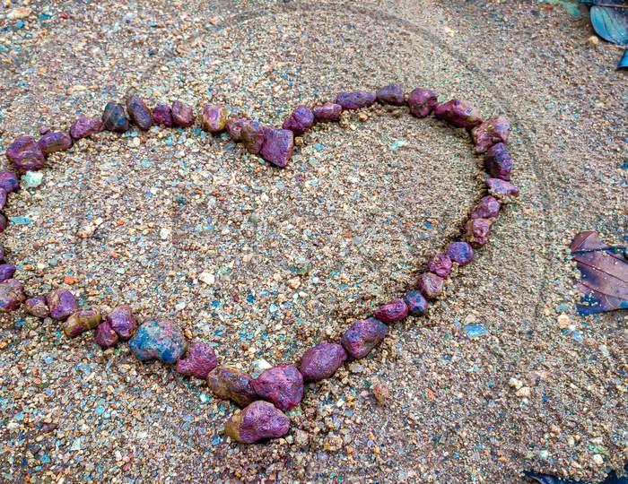 Heart made of Red rock in sand