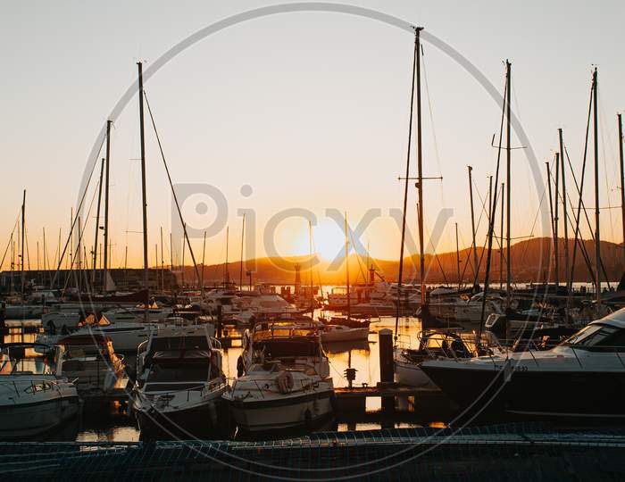 Docks On Spain During A Burning Sunset With A Lot Of Yachts