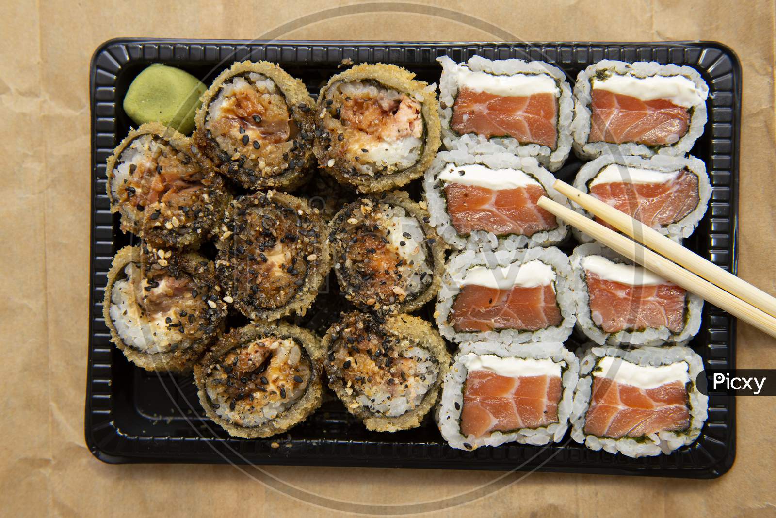 Close Up Of Assorted Sushi With Chopsticks On The Table.