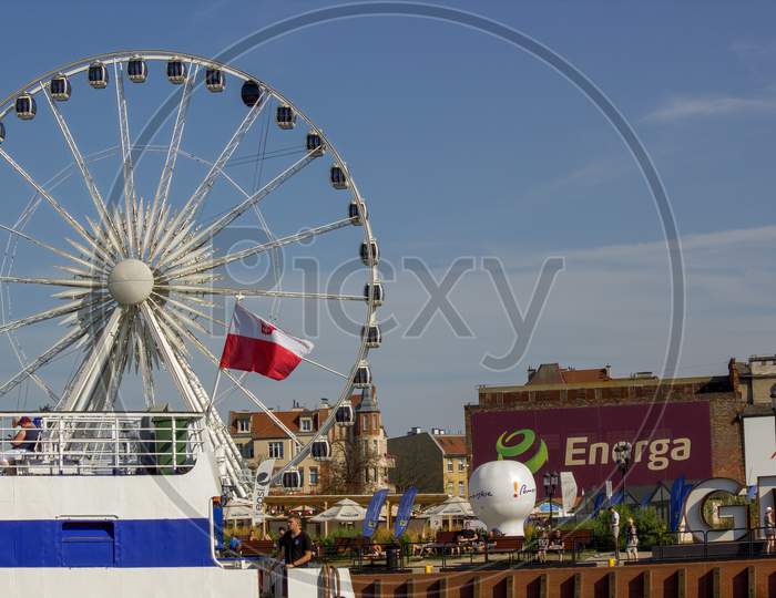 Gdansk, North Poland - August 14, 2020: Ferries Wheel Behind A Motor Boat With Polish Flag Over Motlawa River