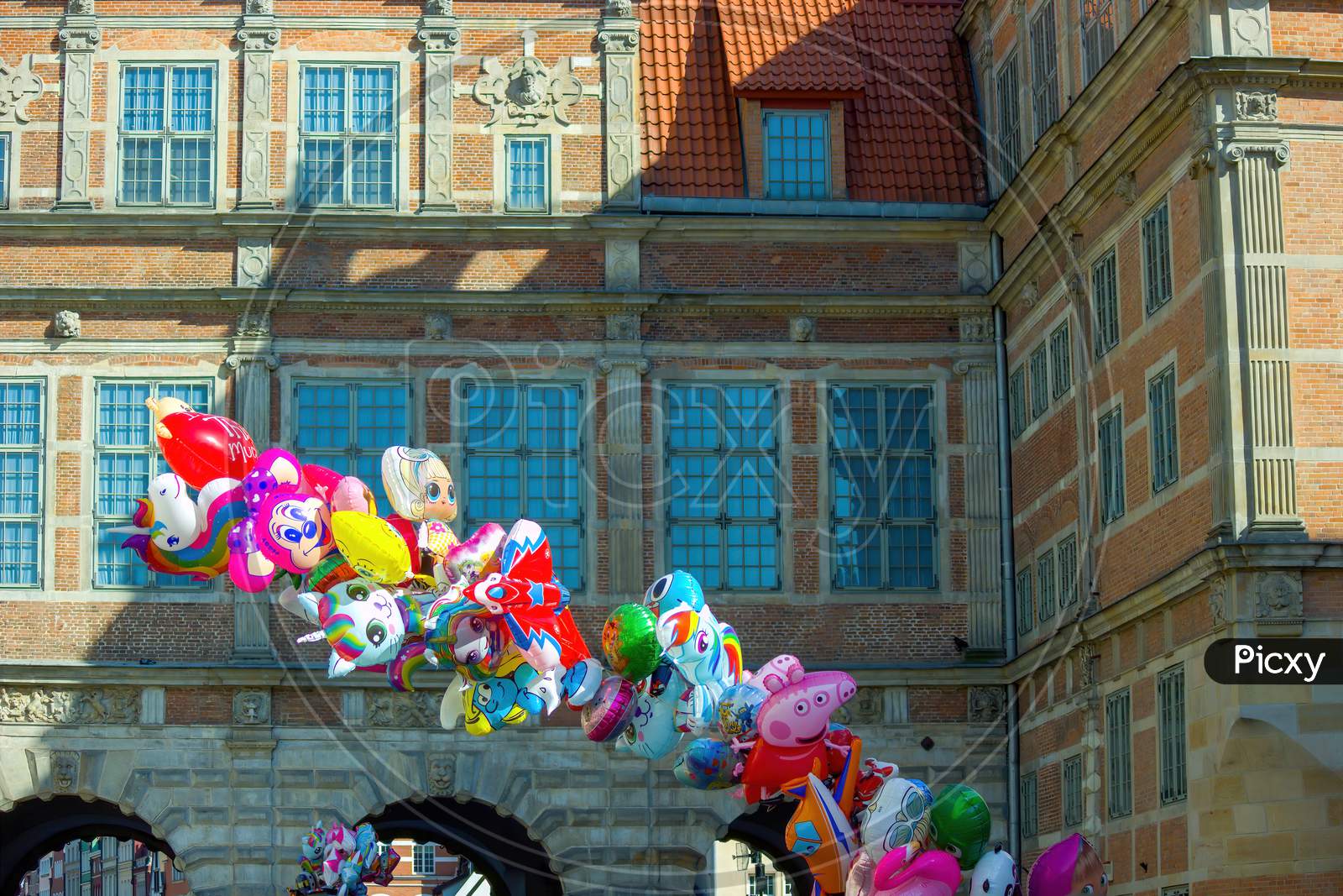 Gdansk, Poland: Bunch Of Balloons In The Shape Of Cartoons Floating In The Street Alley At Old Town Of City Center Main Square