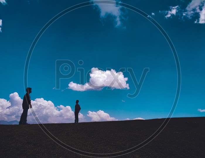 Two persons and the blue cloudy sky.