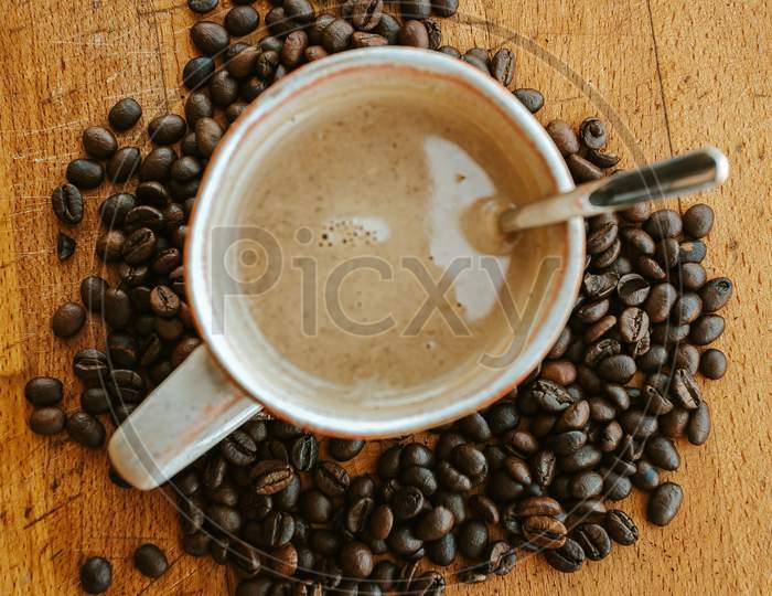 Super Close Up Flat Lay Of A Cup Of Coffee Surrounded By Coffee Grains