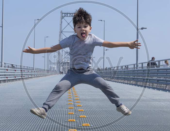 Isolated. Boy Jumping With Arms And Legs Open.