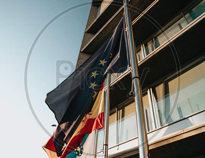 European Flag Waving Surrounded By Other Flags In Front Of A Governmental Building