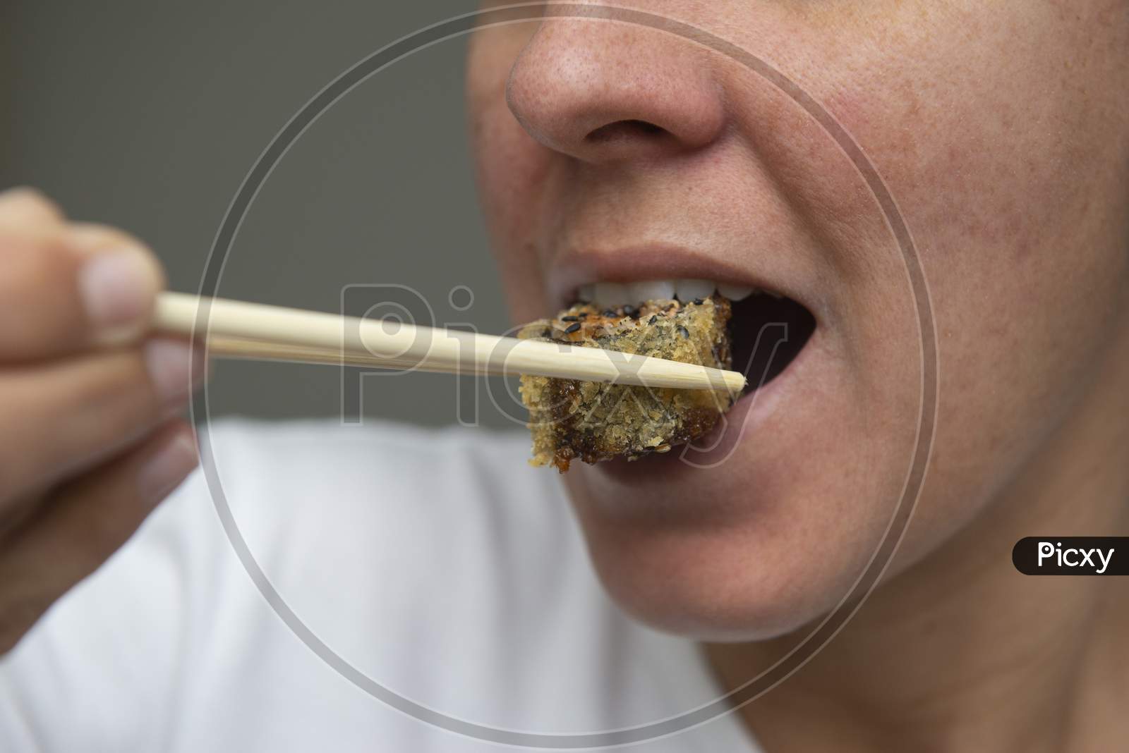 Close Up Of Woman'S Mouth Eating Delicious Salmon Sushi (Hot Roll).