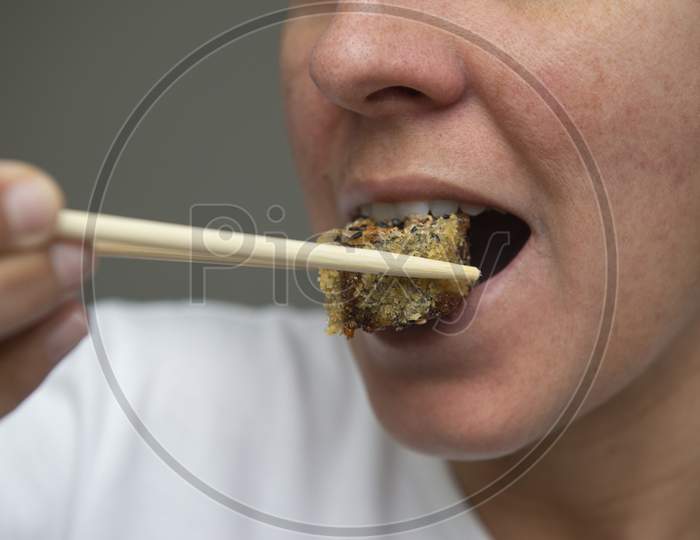 Close Up Of Woman'S Mouth Eating Delicious Salmon Sushi (Hot Roll).