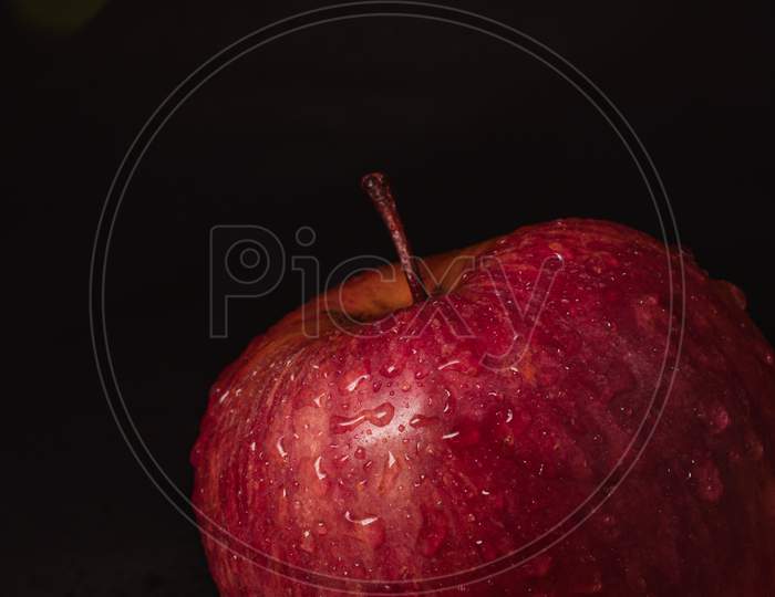 Apple in a dark room with flashlight cast upon it