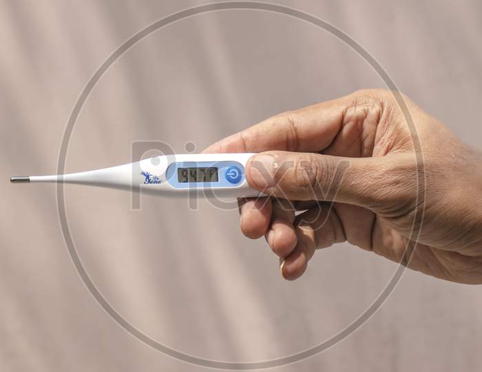 Man Holding Thermometer In Hand.