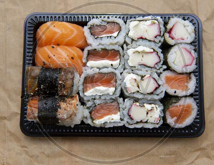 Black Tray With Hot Roll And Salmon Sushi With Cream Cheese. Delicious Food Delivered
