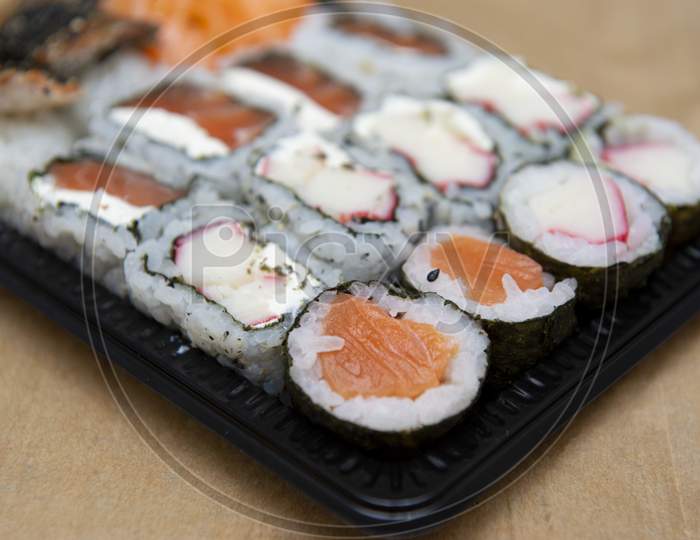 Black Tray With Hot Roll And Salmon Sushi With Cream Cheese. Delicious Food Delivered