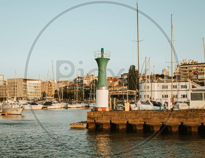 The Green And White Lighthouse In The Sportive Port Of Vigo During A Sunny Day