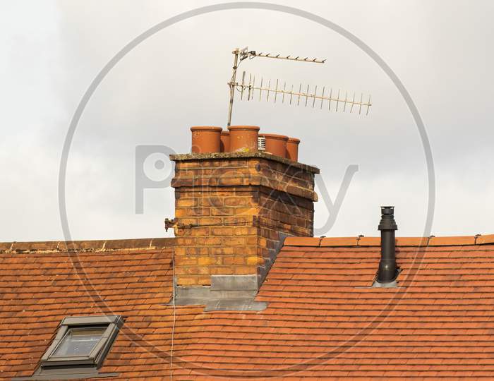 Brick Chimney Stack And TV Aerials On English Rooftop