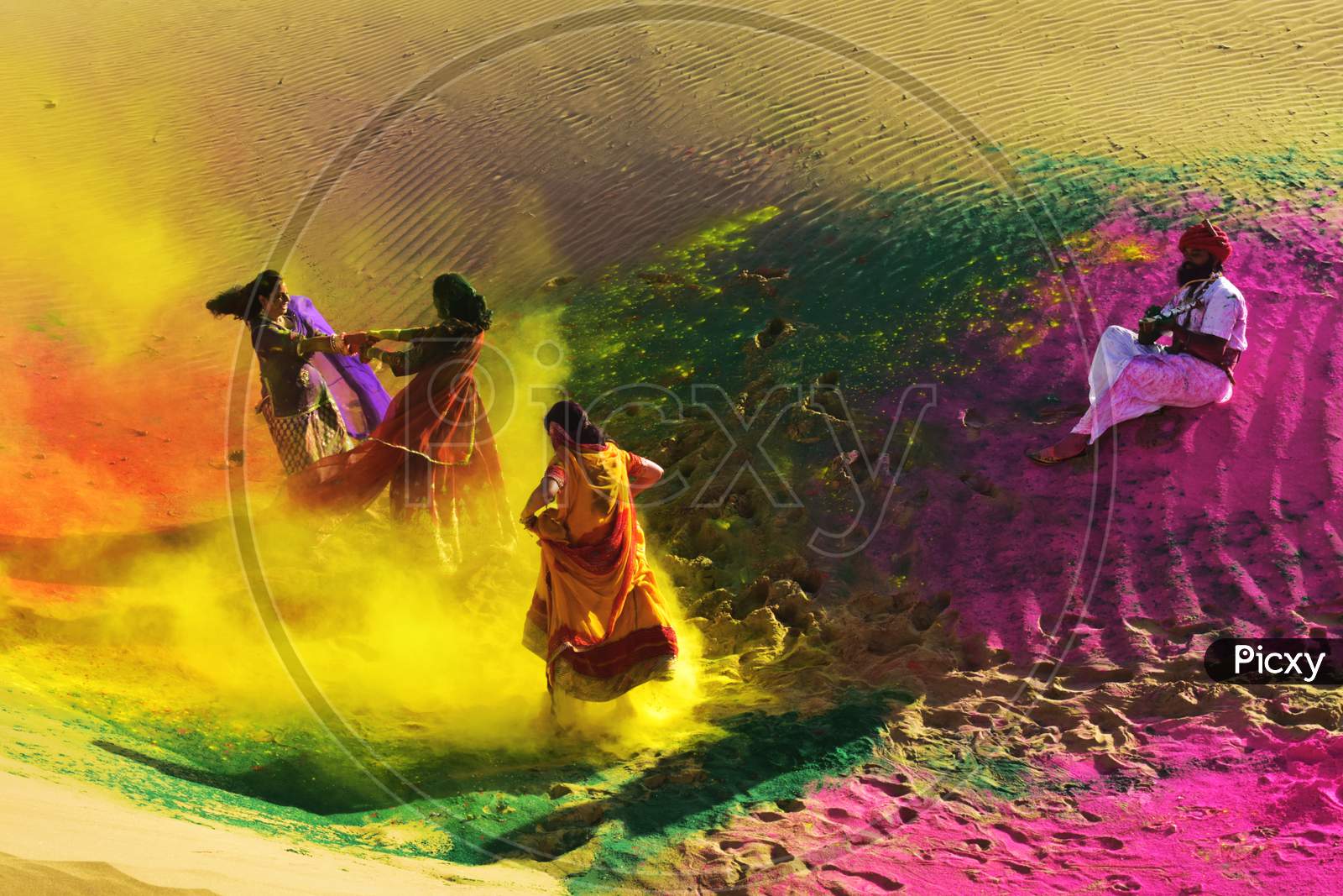 Two Girls And One Man Celebrating Holi, The Festival With Colors And Music