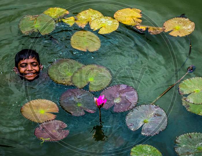 Smiling Boy With Water Lily