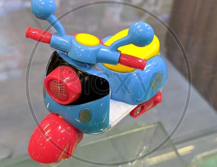 Colourful plastic skooti toy on the glass surface