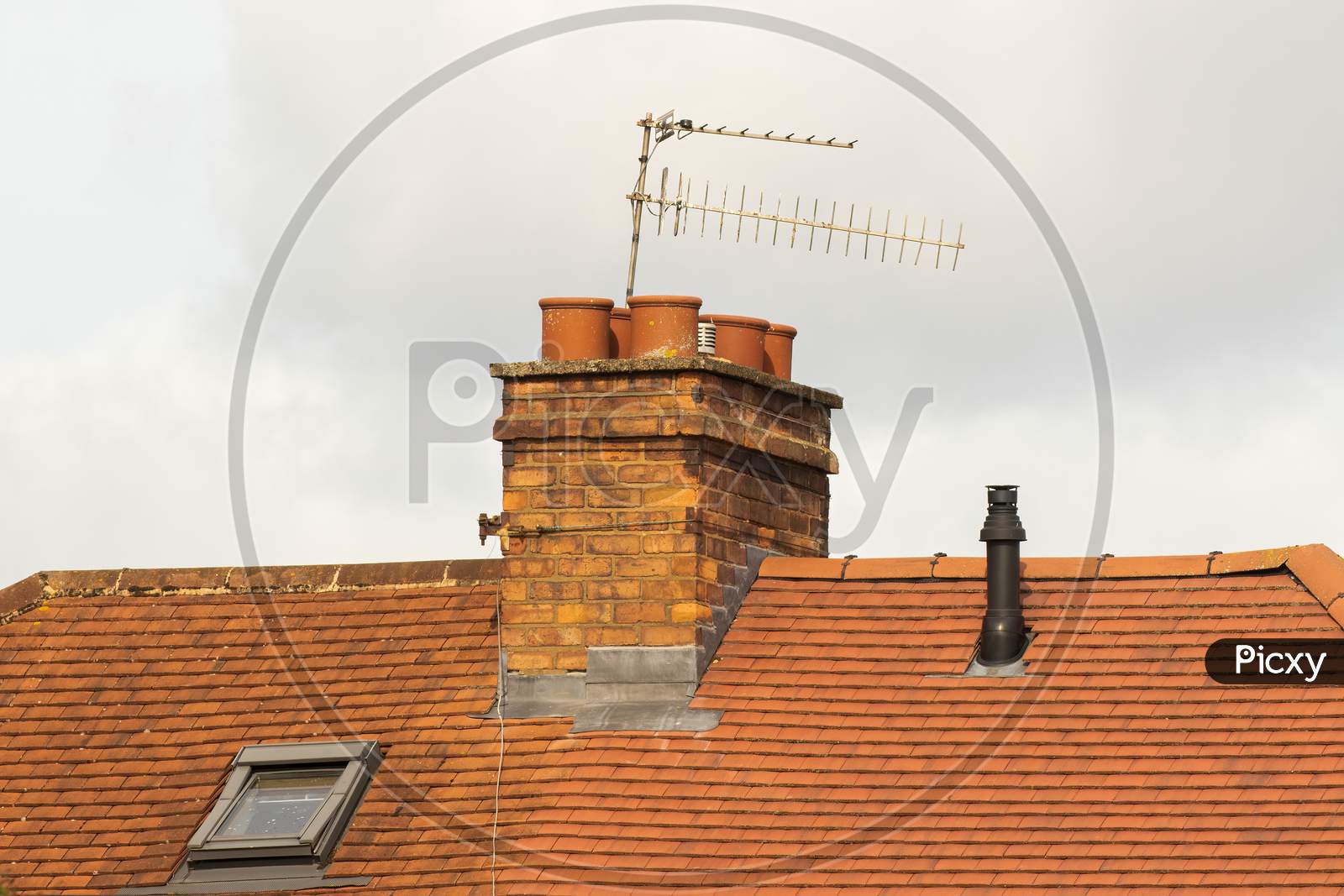 Brick Chimney Stack And TV Aerials On English Rooftop