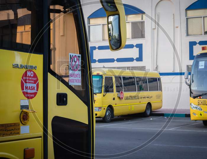 Yellow School Bus In Abu Dhabi, United Arab Emirates, Dubai, Emirates, Gulf, Middle East. Awareness Signs And Symbol Was Written In Arabic Language At School Bus.