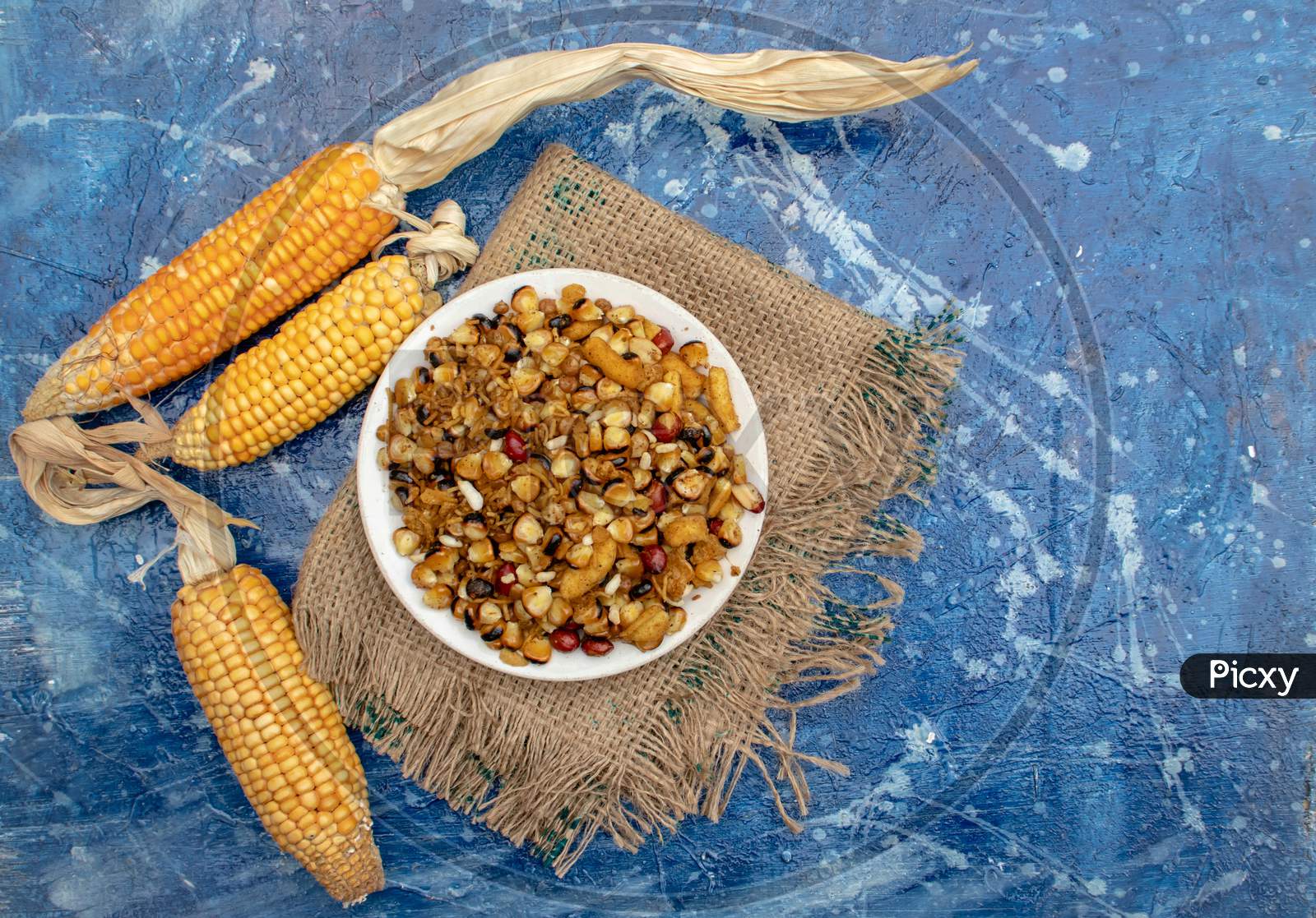 Corn Seeds With Spices In A Plate Isolated On Bluish Background