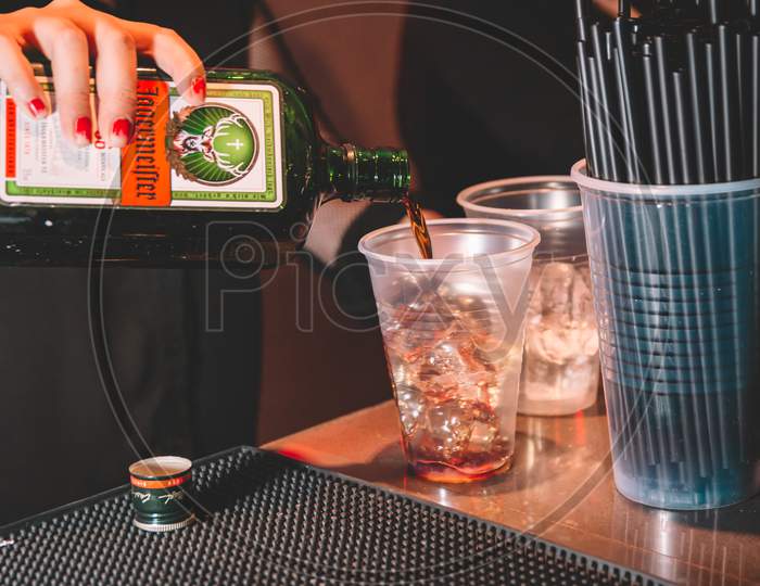 Woman Serving Jagermeister In A Plastic Cup