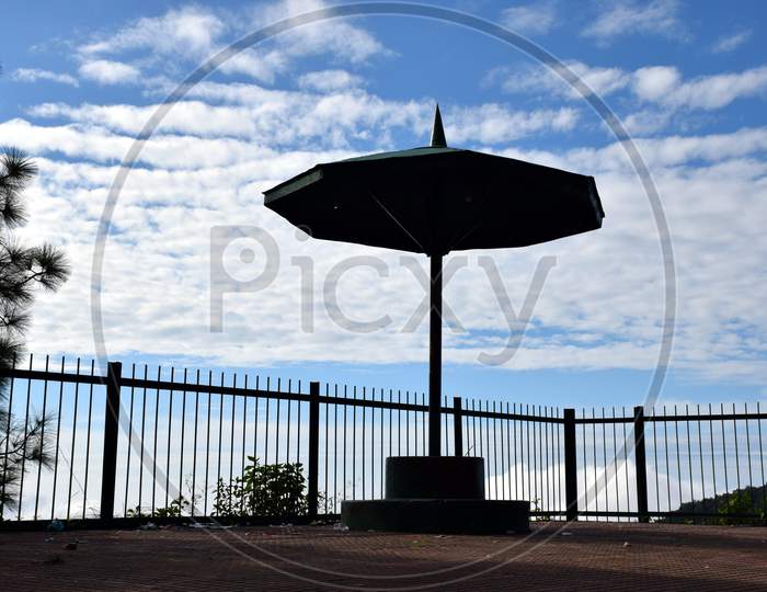 Big Umbrella In Park And Sky In Background