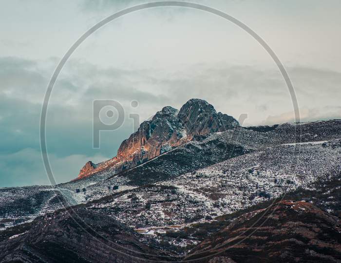 Panoramic View Of A Giant Rock In The Snowy Mountain With The Sunset Reflecting On It