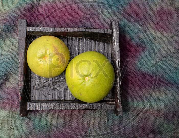 Grapefruit In A Wooden Box Isolated On Burlap Fabric
