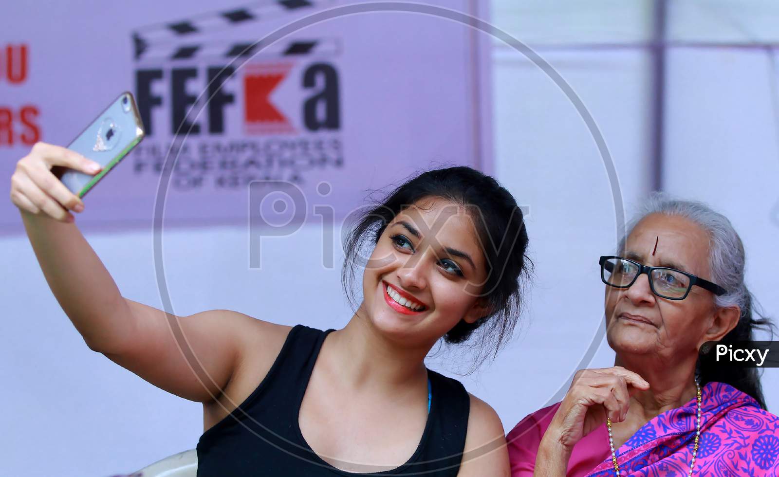 Trivandrum,Kerala/India- 06 Dec 2015 :Actress Keerthi suresh taking selfie with her grandmother during International Film Festival of Kerala, IFFK 2015,On blurred background