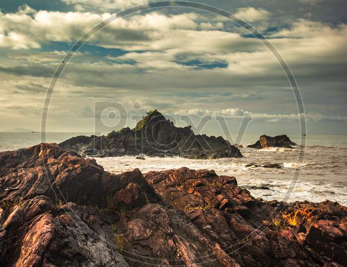 Rocky Sea Beach With Crashing Waves At Morning From Flat Angle