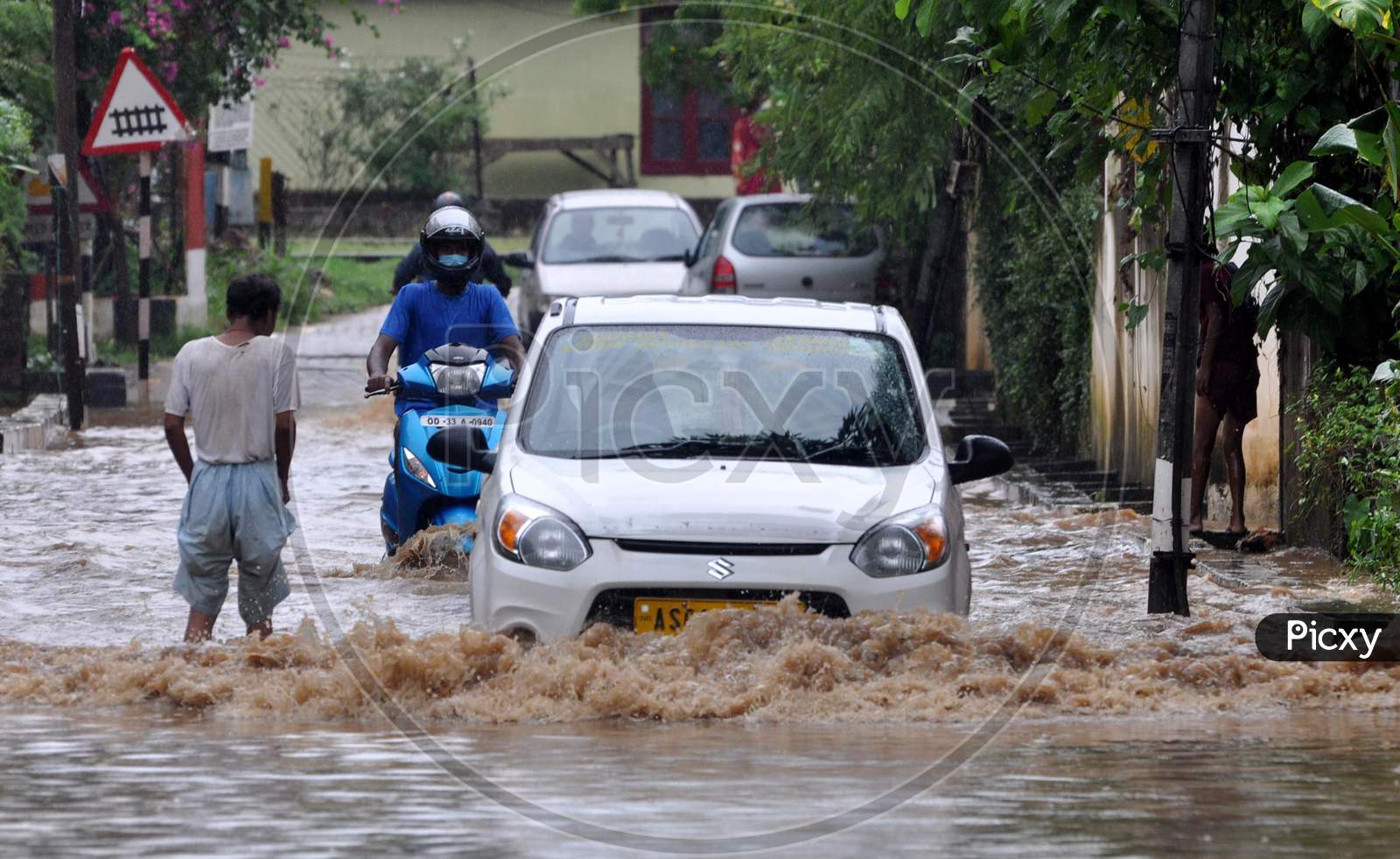 Commuters wade through a water logged street following heavy rains, in Guwahati, India on September 14, 2020