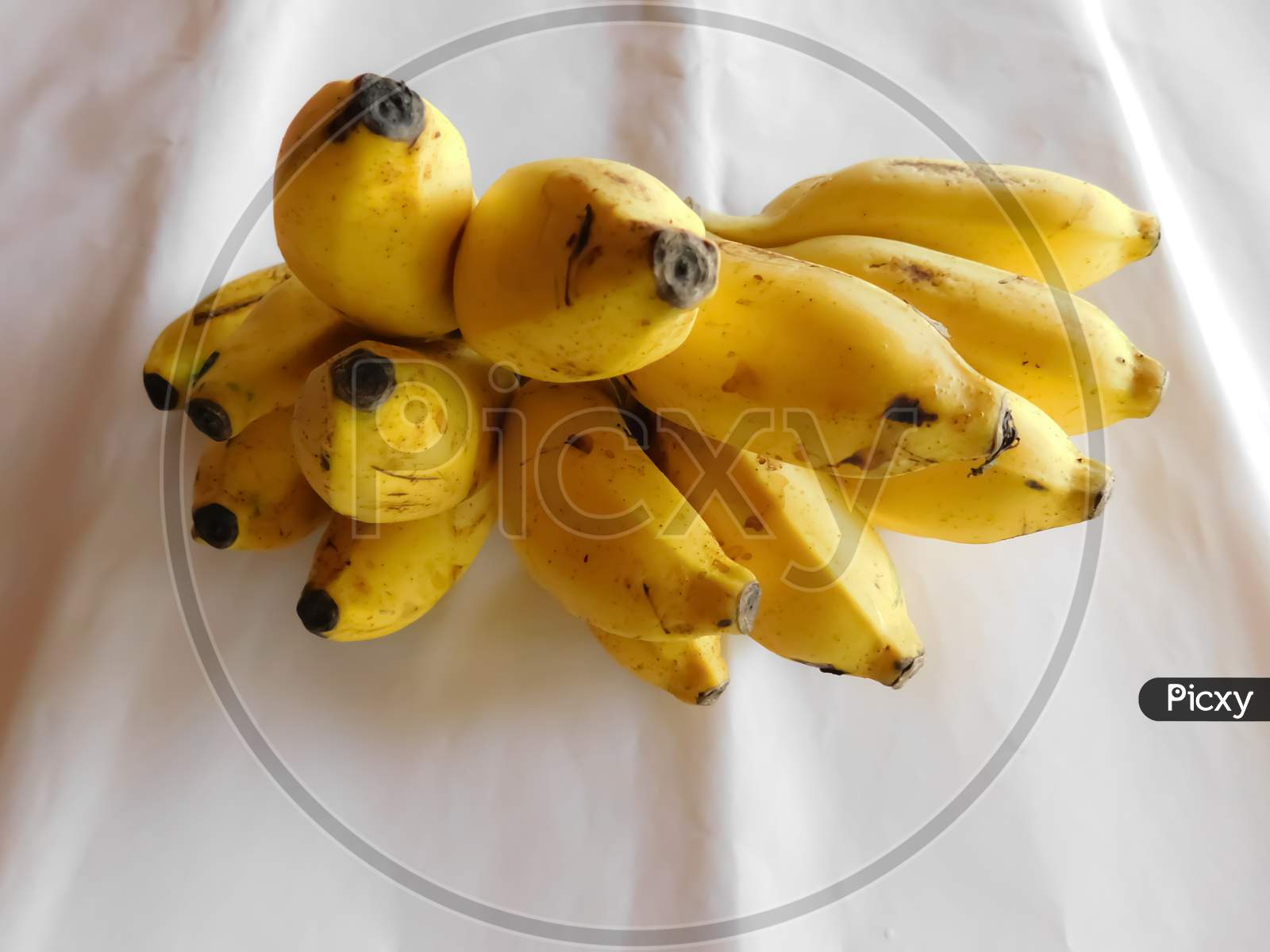 A Bunch Of Bananas Is Placed On A White Surface