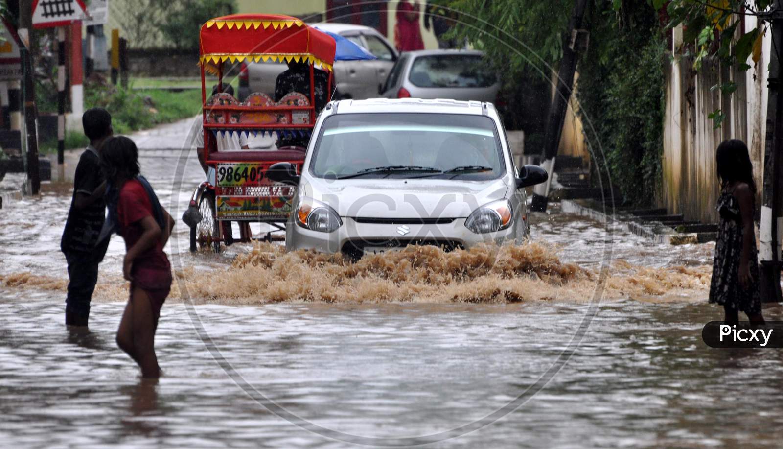 Commuters wade through a water logged street following heavy rains, in Guwahati, India on September 14, 2020