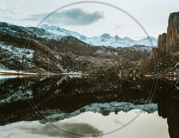 Massive Mountain Reflecting On The Frozen Lake In The Lakes Of Covadonga