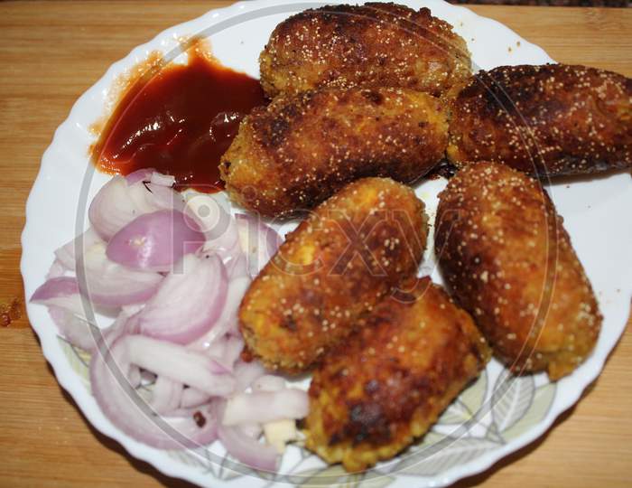 chicken chop served with raw onion and ketchup